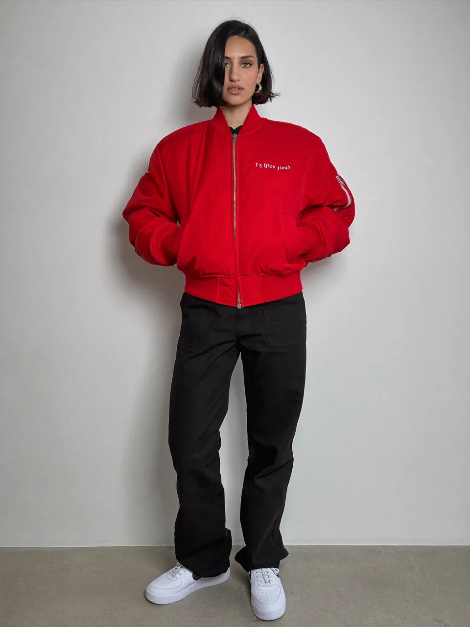 Reference photo of an AI-generated adult woman with a black bob and red jacket